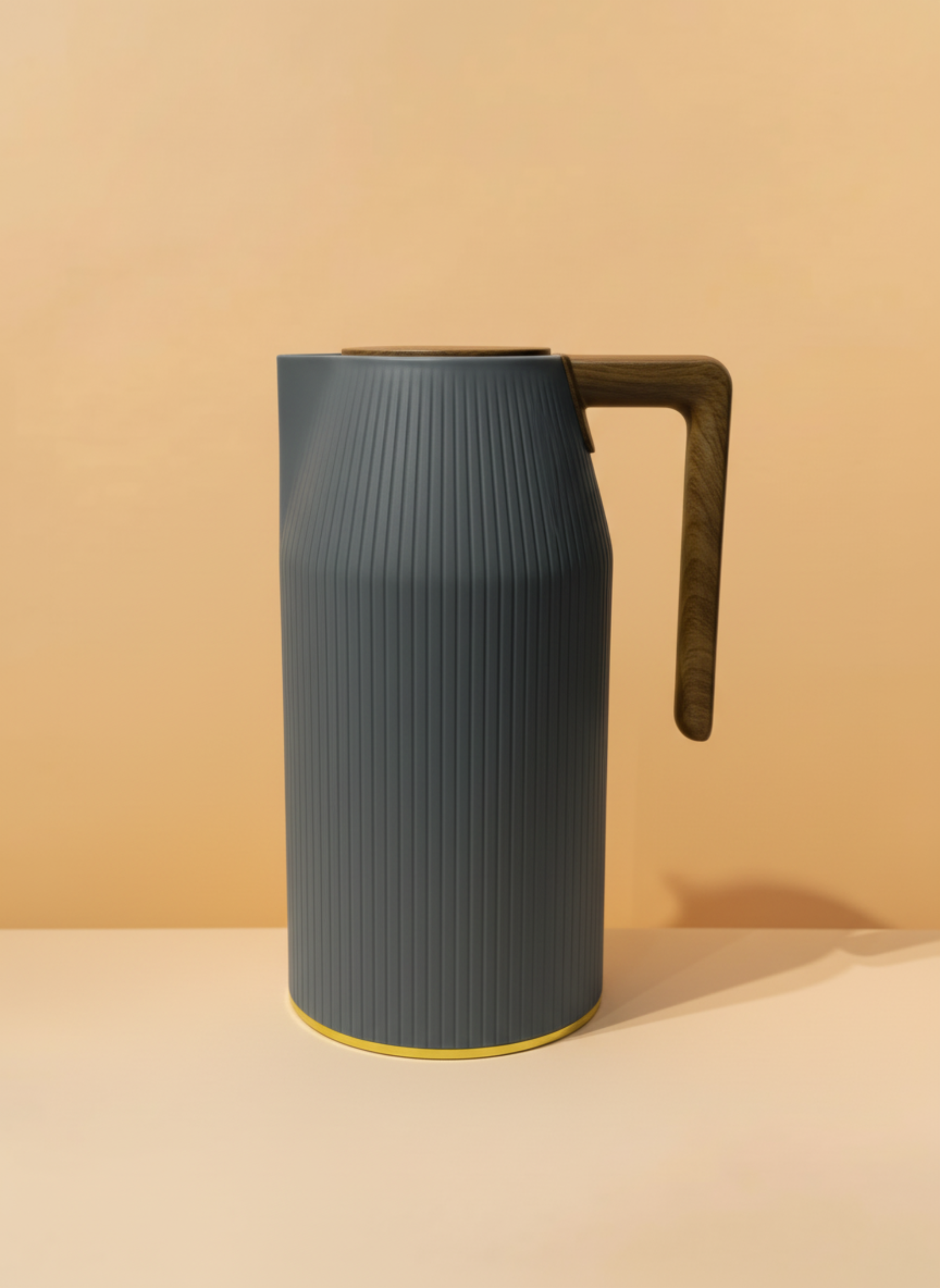 Dark gray pitcher with a wooden handle on a beige background