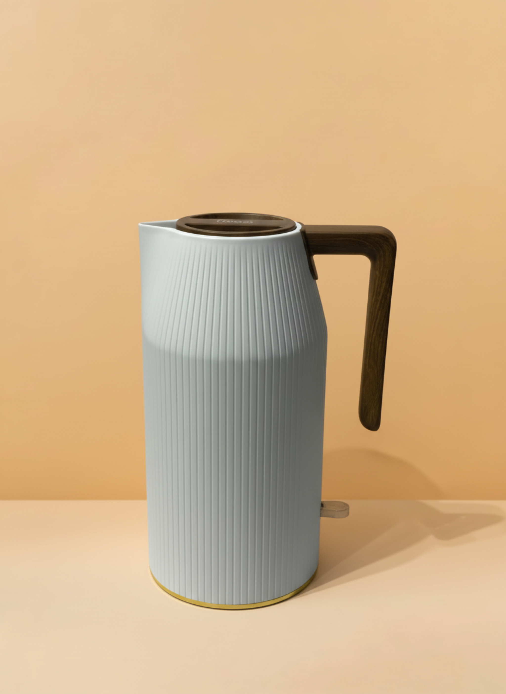 Light blue ceramic pitcher with a dark handle on a beige background