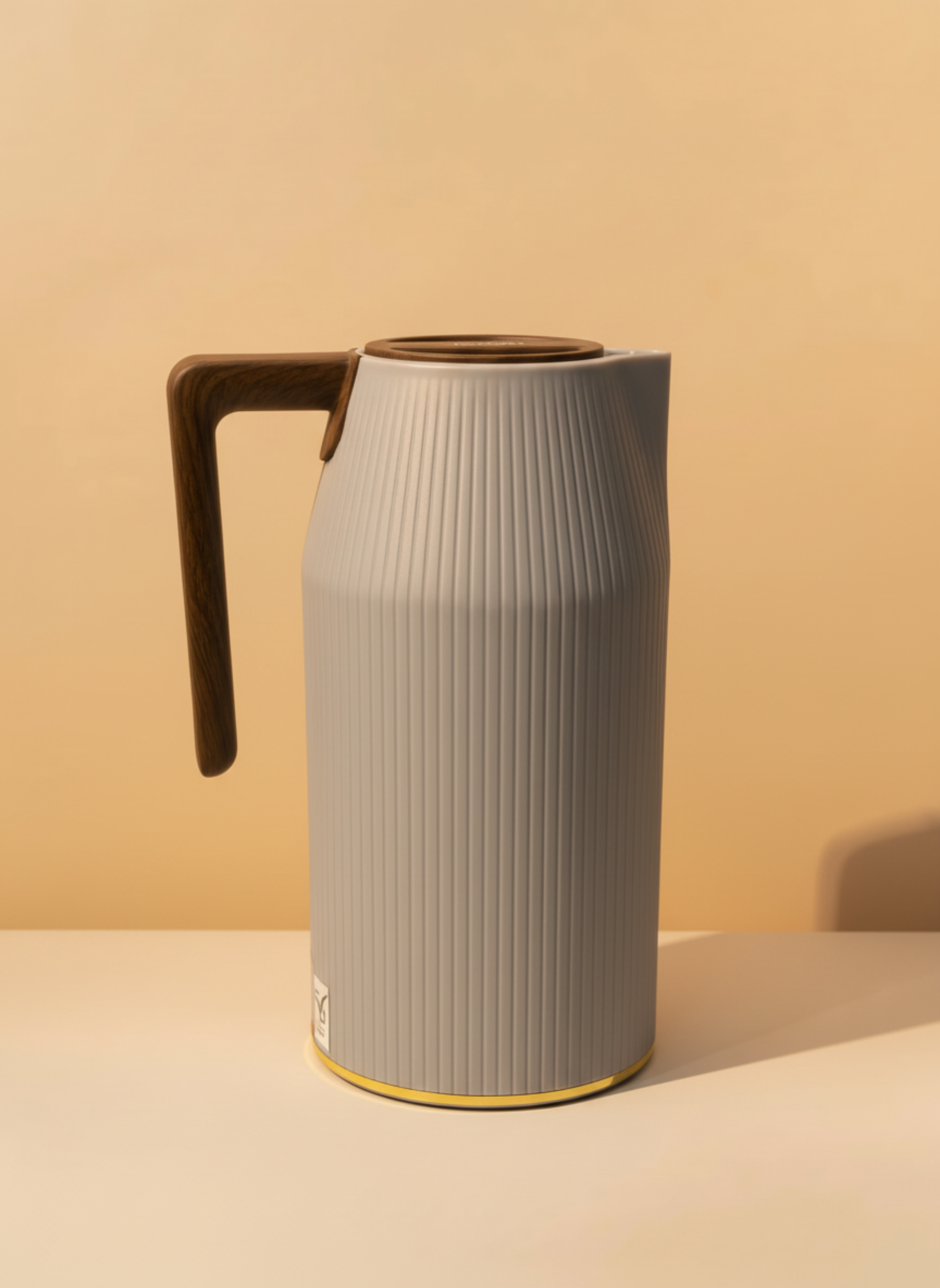 Gray ribbed pitcher with wooden handle on a beige background